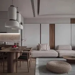 A view of an open-plan living and dining area designed with a Japanese-inspired minimalist aesthetic. The low-profile sofa, natural wood dining set, and paper lantern-style pendant lights create a serene and harmonious environment.