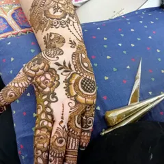 A glimpse of my work in progress. You can see the fresh henna paste on the hand next to the tools of my trade, the henna cones that I use to draw every detail.