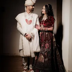 A stylish wedding day portrait of the couple. The groom has his arm around the bride as they look at each other, captured with dramatic lighting that creates a cinematic feel.