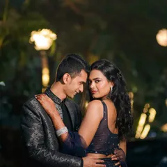 A captivating portrait where the bride looks directly at the camera while embraced by her groom. The soft bokeh of the background lights adds a dreamy quality to this intimate and confident night shot.