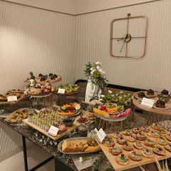 A full view of our stunning Asian grazing table, designed for a festive gathering. This image displays the beautiful arrangement of sushi, sliders, salads, and crostini on a modern black marble table.