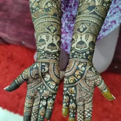 A stunning example of a heavy, full-coverage bridal design. The dark stain makes the intricate details like elephants, birds, and jhumkas pop beautifully.