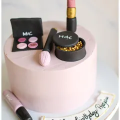 A makeup lover's dream cake. This pink cake is decorated with handmade, edible MAC makeup items, including lipstick, eyeshadow, and brushes.
