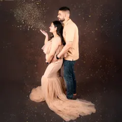 Let's celebrate your journey together. This couple's maternity portrait captures the shared excitement and love, with a touch of magic from the blowing glitter. It’s a fun, dynamic shot that freezes a moment of pure joy.