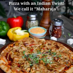 This is our Indian Maharaja Pizza, a pizza with a desi twist. It has a nutritious base of amaranth and ragi, topped with marinated tofu, fresh veggies, and our house-made vegan cheese.