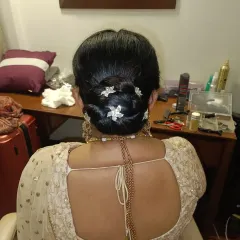 A clean and elegant low bun, intricately twisted and secured for a flawless finish. I adorned this classic updo with small, flower-shaped crystal pins for a touch of sparkle, making it ideal for a reception or formal dinner.