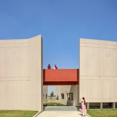 The architecture here is doing a job. These large, fortress-like walls at the SMBV school are shaped to manage Punjab's strong winds and intense sun, while the red bridge creates a pop of color and connection.