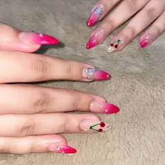 A fun and playful set perfect for a party. These long, stiletto nails feature a hot pink ombre, cherry art, and silver bow charms, all sparkling with tiny rhinestones.