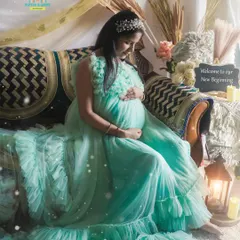 A dreamy, boho-inspired setup created at the client's home. The mom-to-be looks serene in a beautiful mint green gown, surrounded by pampas grass, candles, and soft fabrics.