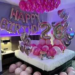 Another popular birthday room decoration, this one for a 26th birthday, combines shades of pink with silver heart balloons. The setup fills the room, covering the bed, floor, and ceiling with festive balloons.