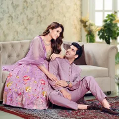 A soft and romantic look for a pre-wedding shoot or reception. The couple is styled in coordinating shades of lavender, with her in a floral lehenga and him in a subtly embroidered sherwani.