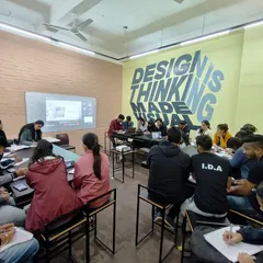 Students engaged in a practical session, with a presentation visible on screen. I use real project data and case studies to ensure the learning is grounded in actual industry practice.