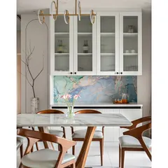 This dining area features a stunning blue marble-finish laminate backsplash, which provides the luxurious look of real stone at a more accessible price point. Paired with elegant wooden chairs and a modern pendant light, it creates a space that is both artistic and functional.