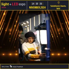 A visitor closely inspects an outdoor lighting fixture, showcasing the hands-on opportunity to evaluate product quality and design.