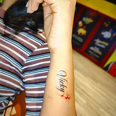 Here is another example of a custom name tattoo, this time in an elegant cursive font with a small color accent. We can personalize your temporary tattoo with different styles and small graphic elements to make it truly yours.
