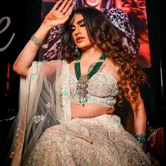 A powerful shot of Sushant Divgikar in a heavily embellished lehenga. The makeup is full glam, with a smokey eye, contoured cheeks, and a bold lip, designed to stand out on stage.