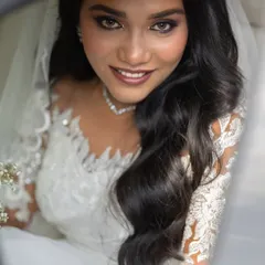 A stunning close-up of the bride, her eyes and smile radiating happiness as she sits in the wedding car.