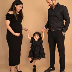 A playful moment during a studio maternity shoot. Holding hands and swinging their daughter, this photo perfectly captures the fun and happiness of this growing family.