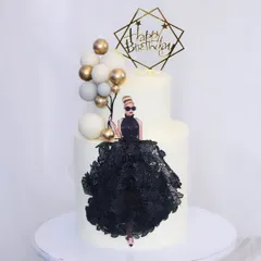 A sophisticated cake for the diva on her special day. This two-tiered white cake features an elegant edible print of a woman in a stunning black lace gown, accented with a balloon-like cluster of white and gold spheres.