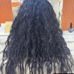 A dramatic "before" picture showing very curly and frizzy hair prior to a Nanoplastia treatment.
