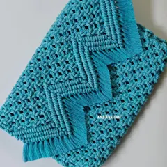 A close-up view of the texture and knot work on my turquoise macrame purse. You can see the detailed berry knots and the neat diagonal lines that form the flap, finished with a soft fringe. It's all in the little details.
