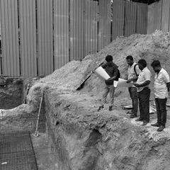 On-site, our team reviews blueprints against the excavated foundation. This is a critical step in our turnkey process, ensuring the architectural vision is accurately translated from paper to ground.