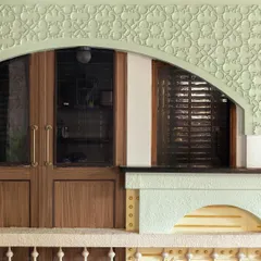 A close-up of the architectural details at Soley Cafe. The pastel green arch with intricate molding and the warm wood of the doors reflect a blend of European classicism and modern craftsmanship.