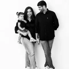 A stylish black and white family portrait. The family's coordinated casual outfits and loving interactions make for a modern and timeless image.
