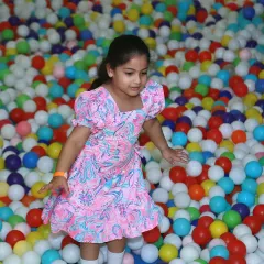 A young guest navigates a sea of colorful balls, showcasing the fun and playful atmosphere of a birthday at a play zone.