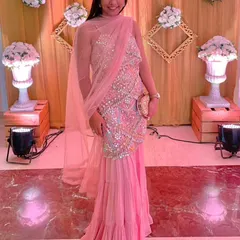 This three-layered sharara in a soft pastel peach is all about delicate details. The top layer is intricately embroidered with shells and mirrors, creating a beautiful texture that is both traditional and chic.