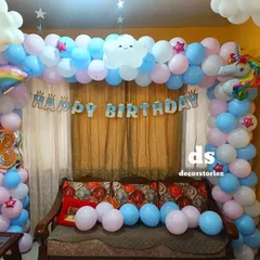 A dreamy rainbow and unicorn themed party setup. This decoration features a pastel balloon arch with a unicorn foil, a rainbow cutout, and a 'Happy Birthday' banner, creating a magical atmosphere in your home.