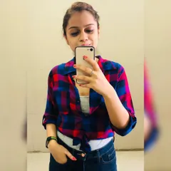 An oversized plaid shirt can be styled in many ways. By tying it at the front over a basic tank top, you can instantly define your waist and create a more flattering, curved silhouette. This is a simple trick I teach to make your clothes work for you.