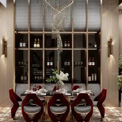 A closer view of the dining area within a double-height space. The spiral chandelier acts as a centerpiece, complemented by a built-in wine display and rich, red velvet chairs, making it a perfect setting for a formal dinner.