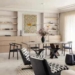 The open-plan living and dining area of Apartment O2 is designed for family connection. The space is bright and airy, with a calming backdrop of soft, raw cotton hues on the walls.