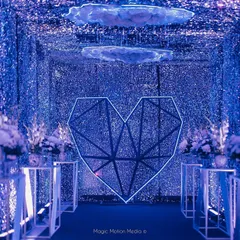 We love creating immersive entrances. For this celestial-themed Sangeet, we built a 'Tunnel of Love' with thousands of glittering blue sequins, a geometric heart, and floating clouds to transport guests into another world.