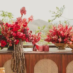 Details from our 'Gulmohar Bagh' Haldi theme. The decor featured rich red floral arrangements, wooden furniture, and traditional elements that complemented the natural hillside backdrop.