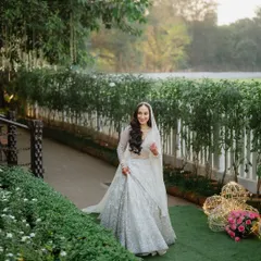 The bride taking a stroll in the garden at Gallops, Mumbai, looking serene and beautiful in her white wedding lehenga.
