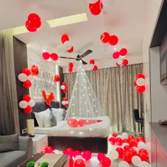 A classic romantic room decoration for a special surprise. I used red and white balloons on the floor and ceiling, a canopy with fairy lights over the bed, and rose petals to make it extra special.