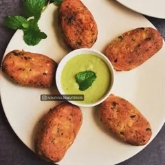 These are our vegetable cutlets, golden-fried and served with a fresh mint chutney. They are a classic and beloved appetizer for guests of all ages.