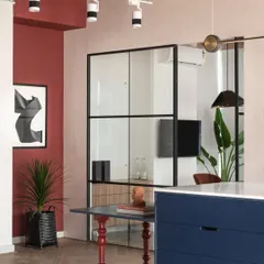 To break up a plain corner near our material island, I added a bold red accent wall that flows with the studio's theme. A beautiful piece of abstract art and a statement plant complete this little nook, giving it character and energy.
