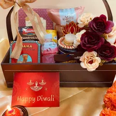 A sophisticated leatherette basket filled with assorted snacks, a lotus diya, and beautiful flowers. This premium Diwali hamper is perfect for corporate clients or close family.