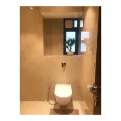 A minimalist master bathroom transformation. We used large-format marble-look tiles for the walls and a simple floating toilet to create a clean, spacious, and serene feeling.