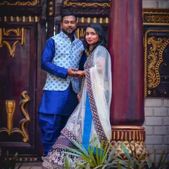 This couple is dressed in a beautiful coordinated set, featuring a blue silk kurta with a printed Nehru jacket and a matching embroidered lehenga.