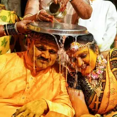 A traditional Haldi ritual where water is poured over the couple, symbolizing purification and blessings before their union.