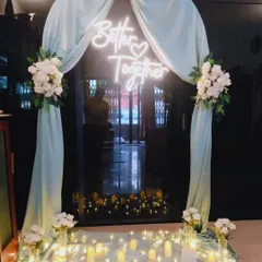 For this intimate home engagement, I created a romantic entryway using a soft pastel arch, white floral arrangements, and a custom 'Better Together' neon sign. The warm fairy lights and floor candles add a magical glow, perfect for evening celebrations.