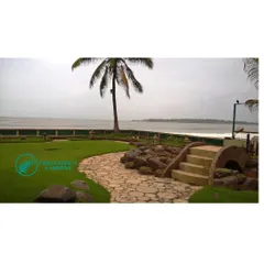 This beautiful seafront villa garden is one of our pride and joy projects. We designed a landscape with a mix of durable lawns, salt-tolerant plants, and hardscaping elements like this stone path and bridge that withstand the coastal climate.