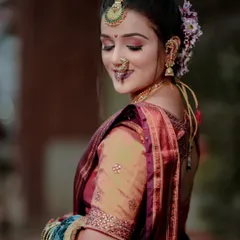 A beautiful side profile of a Maharashtrian bride, showcasing her elaborate hairstyle with flowers and traditional jewellery.