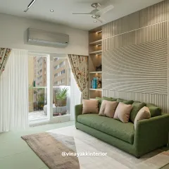 Here, a pop of color from the green sofa brings life to a neutral space. The fluted wall paneling and built-in shelving add architectural interest and provide a stylish solution for storage and display.