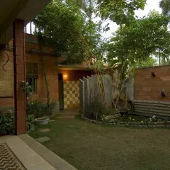 The Sharada Residence is designed around a central courtyard that functions as an outdoor room. This space brings light, air, and nature into the core of the house, with features like an open-air shower and integrated landscaping.
