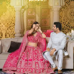 A playful and happy moment from a campaign shoot. The bride's bright pink lehenga is full of life, while the groom's simple yet elegant white kurta set provides the perfect balance.
